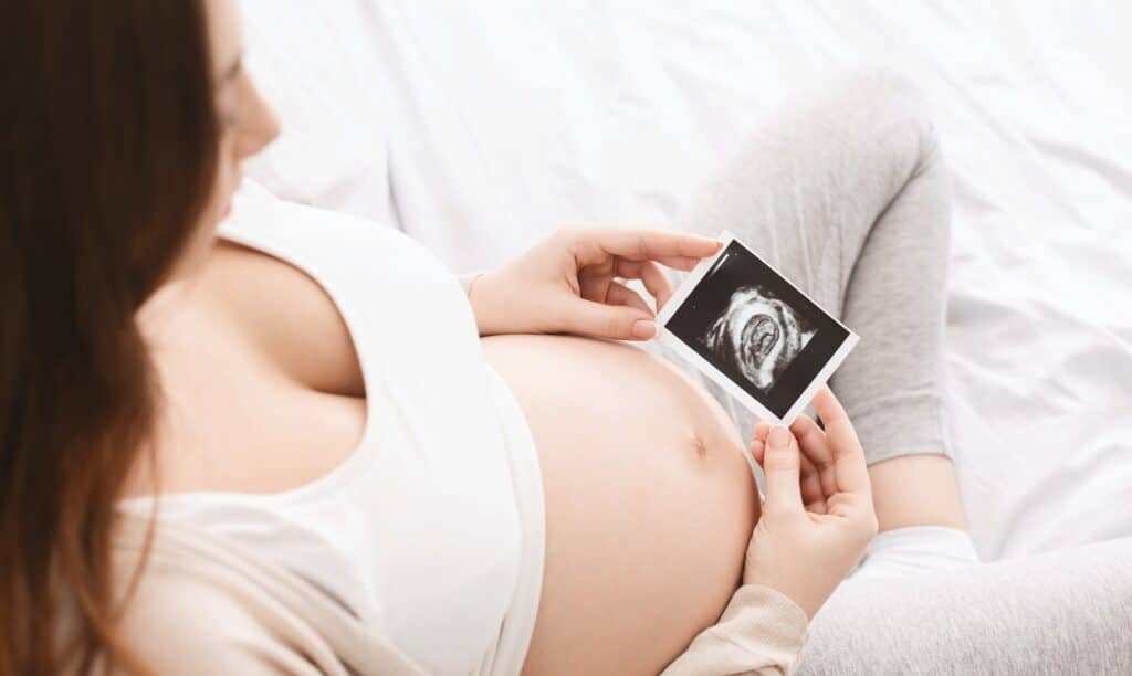 Pregnant woman enjoying her baby ultrasound image